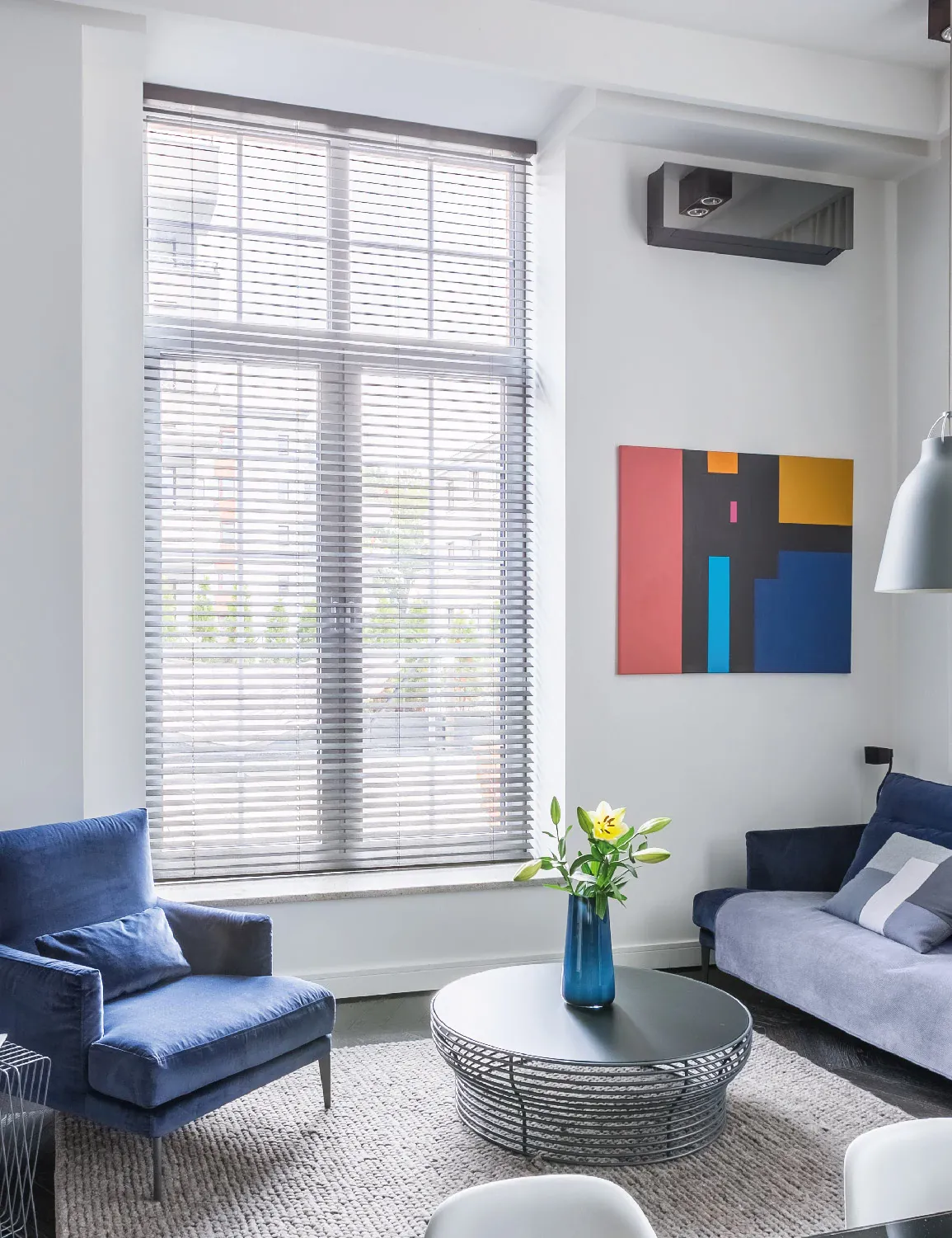 La persiana horizontal de aluminio es sutíl y práctica, ideal para espacios compartidos de uso contínuo.