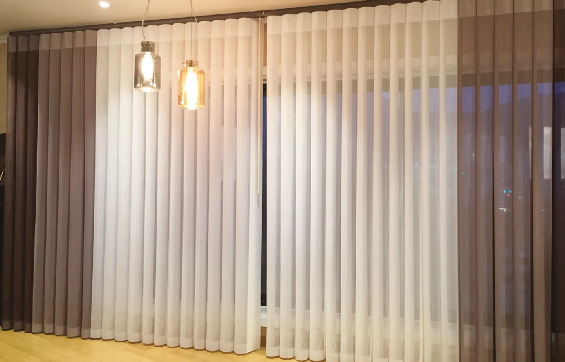 La combinación entre persiana vertical y cortina. Esta bella e innovadora persiana permite el paso del aire entre sus tejidos individuales.